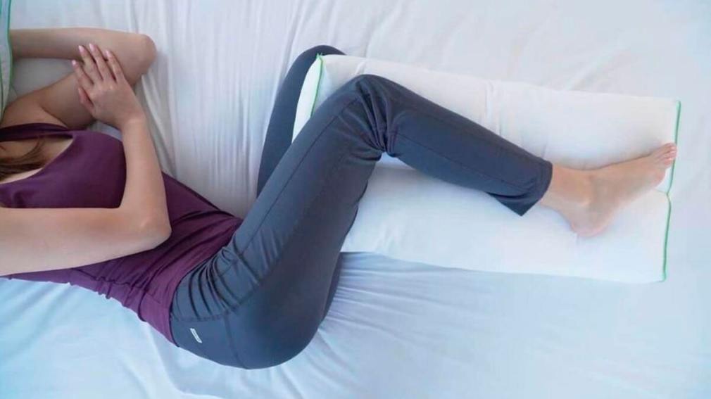 Los beneficios de dormir con una almohada entre las piernas